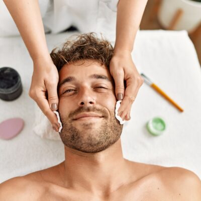 Young hispanic man having facial treatment at beauty center Young hispanic man having facial treatment at beauty center